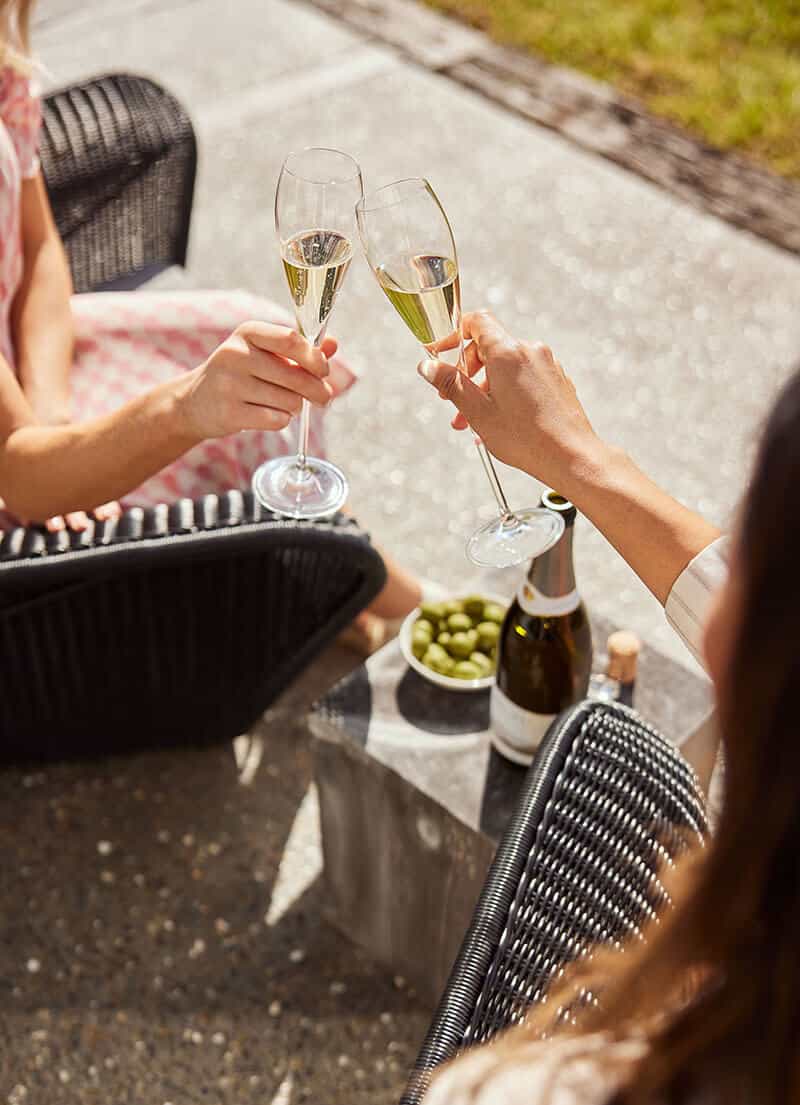 Two women clinking glasses of Cloudy Bay Pelorus sparkling wine