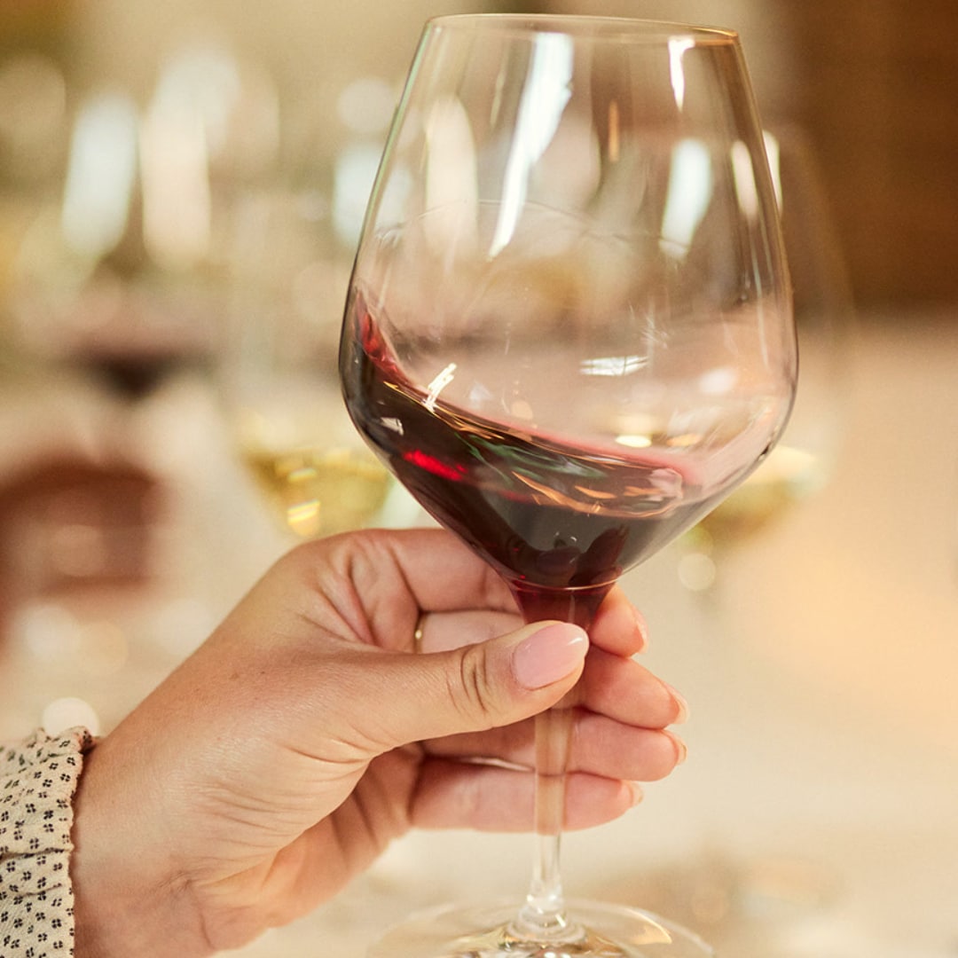 hand holding glass of red wine