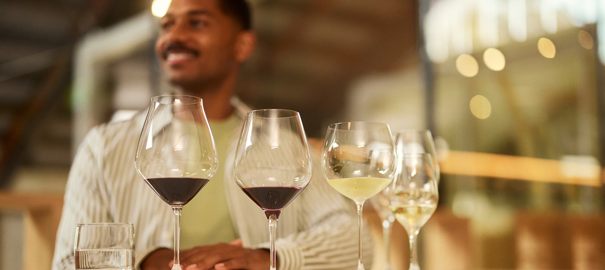 person sitting at table tasting wine