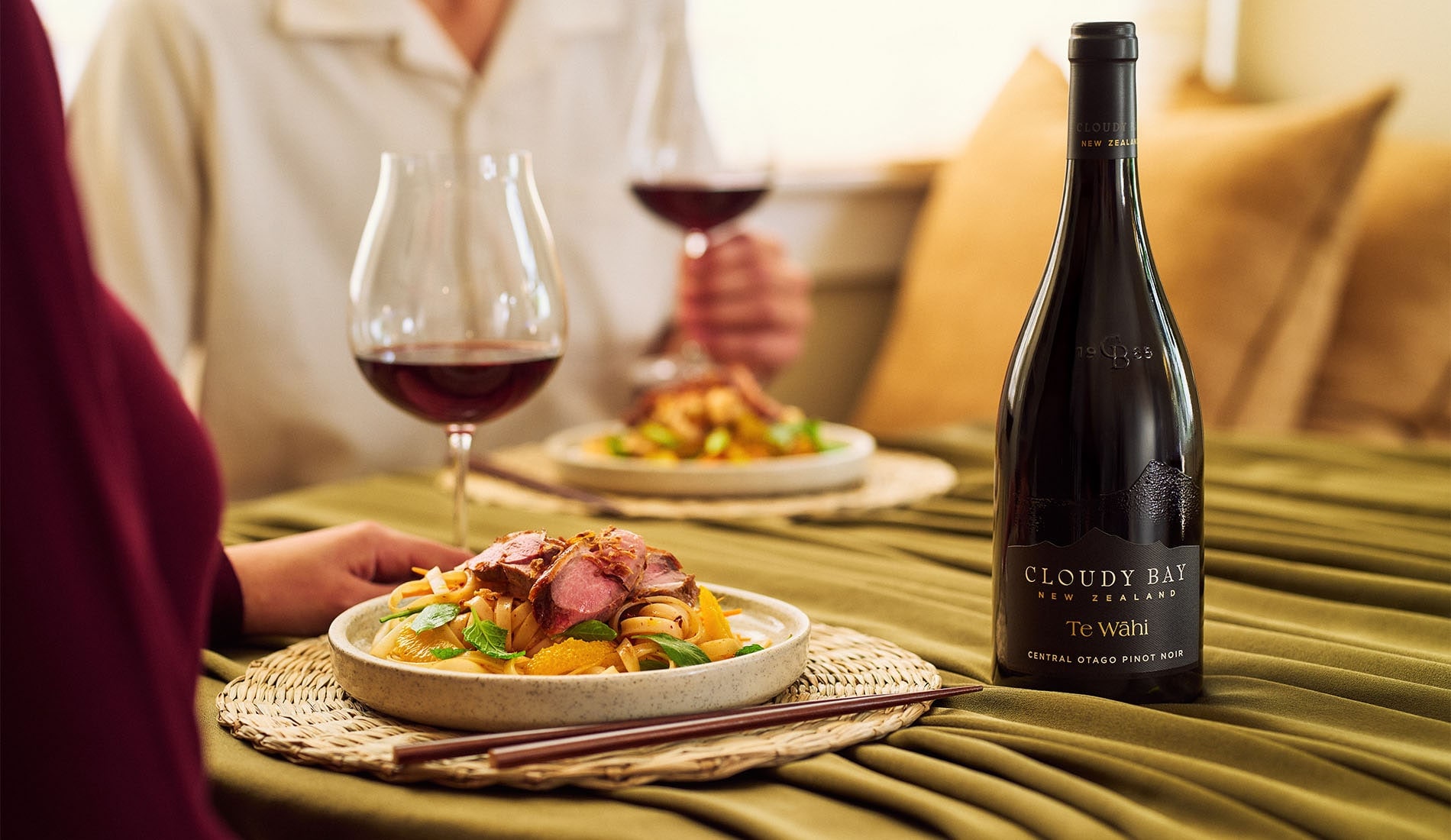 Crispy Duck on noodle salad with glass and bottle of Te Wahi