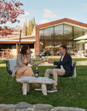 Two people seating in front of The Shed