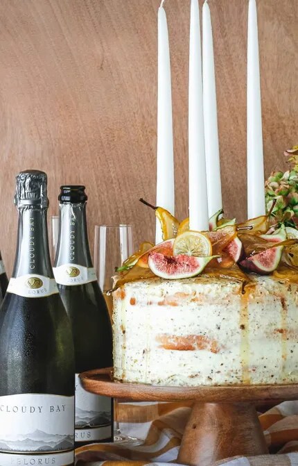 Large cake with figs beside 3 bottles and glasses of Cloudy Bay Pelorus 