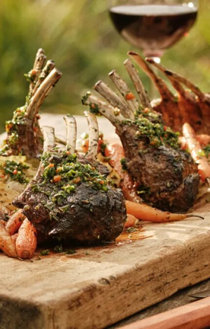 Plate of Lamb Racks with Mint Chimichurri and a bottle of New Zealand Pinot Noir