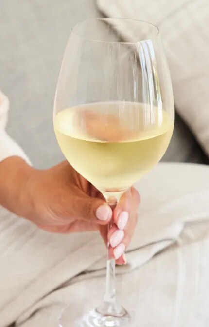 person enjoying glass of wine at home