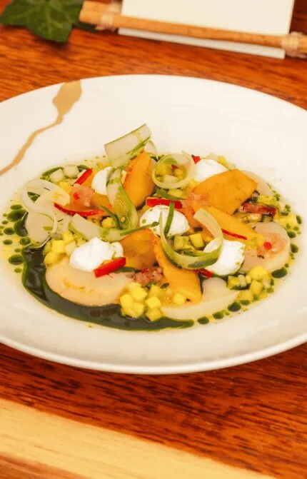 White plate with Scallop Ceviche on a wood table