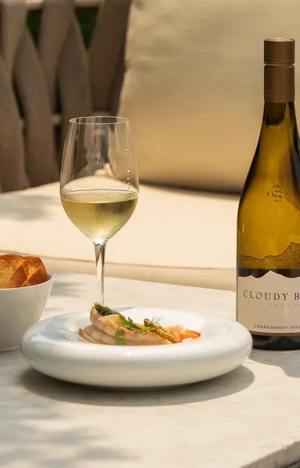 Sunny table with Pan Seared Prawns and Cloudy Bay Chardonnay Bottle